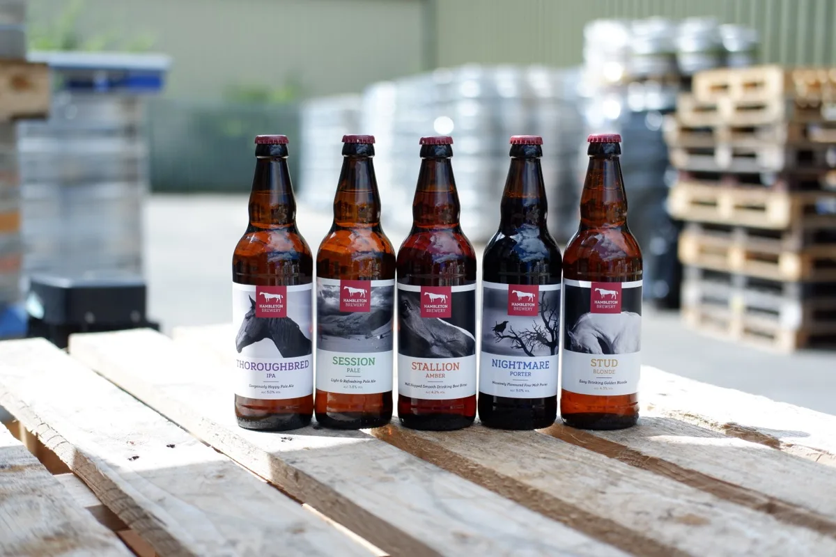 Five gluten free Hambleton beers in bottle, Thoroughbred IPA, Session Pale, Stallion Amber, Nightmare Porter and Stud Blonde, on a pallet in the brewery yard